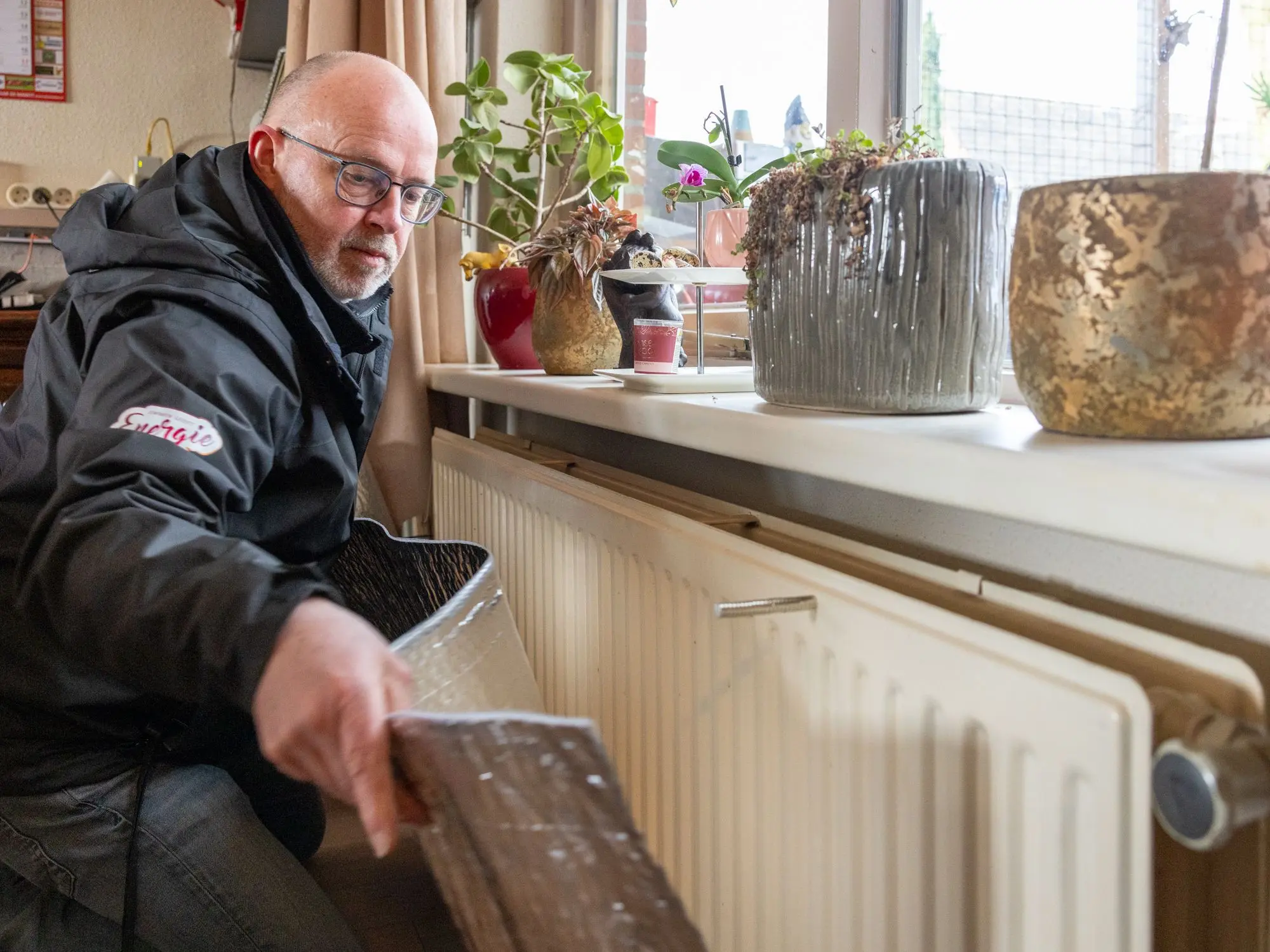 Fixer Edwin brengt radiatorfolie aan.